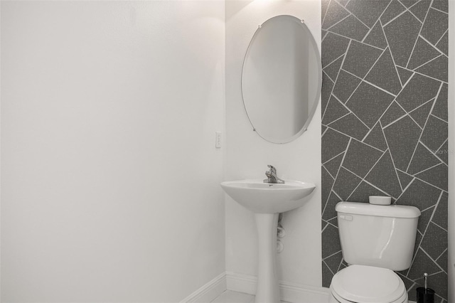 bathroom with sink, tile walls, and toilet