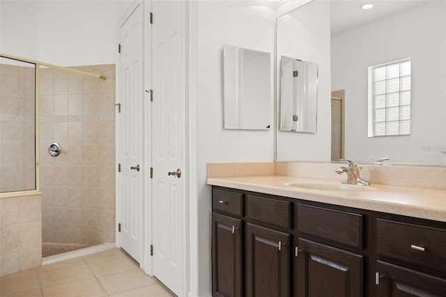 bathroom with a tile shower, tile patterned flooring, and vanity