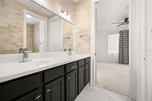 bathroom with vanity, ceiling fan, and tile walls