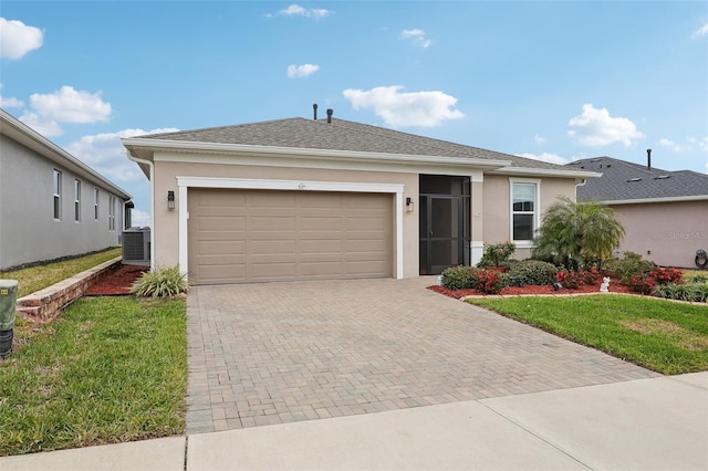 ranch-style home featuring a front yard, a garage, and cooling unit