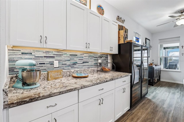 kitchen featuring white cabinets, tasteful backsplash, light stone countertops, and ceiling fan