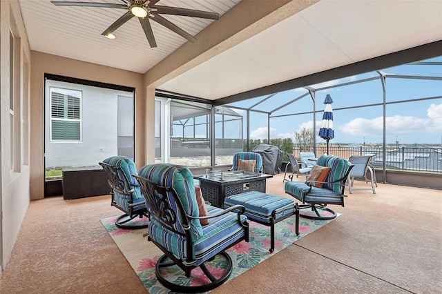 view of patio / terrace with ceiling fan, a lanai, and an outdoor living space with a fire pit