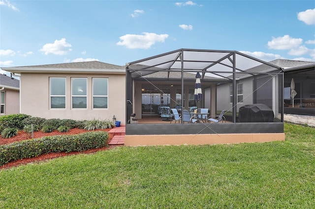 rear view of house featuring a lanai, a yard, and a patio