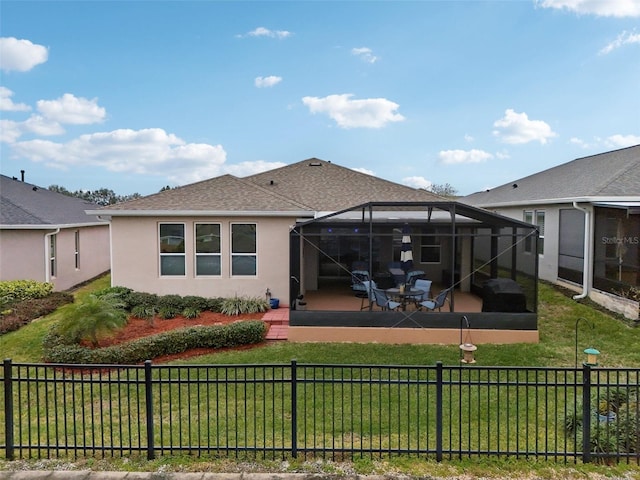 back of property featuring a patio area, a lanai, and a lawn