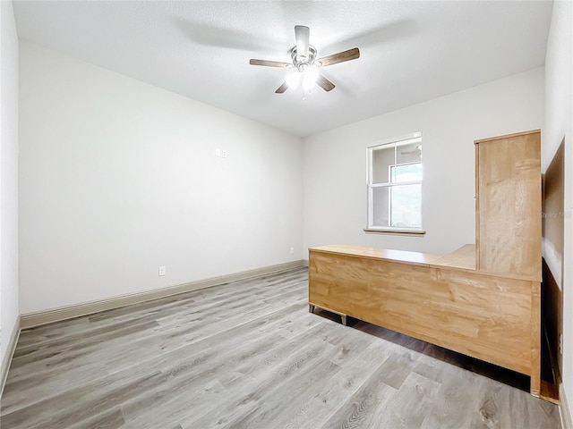 empty room featuring ceiling fan, a textured ceiling, and light wood-type flooring