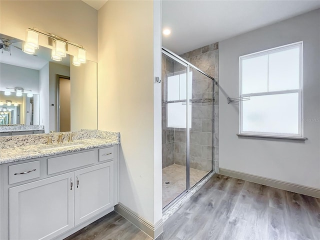 bathroom with hardwood / wood-style flooring, vanity, and walk in shower