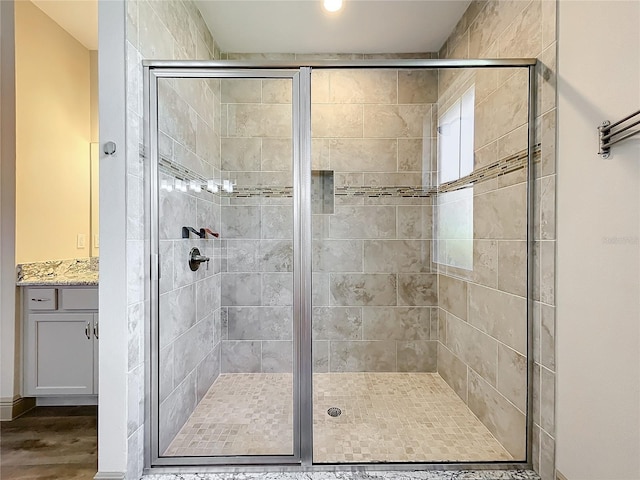 bathroom with hardwood / wood-style flooring and a shower with shower door