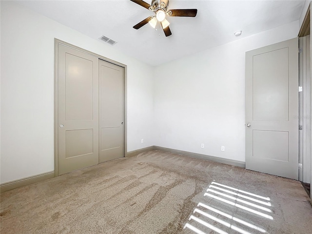 unfurnished bedroom with ceiling fan, a closet, and light carpet