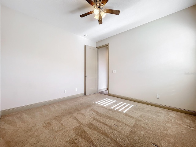 carpeted spare room featuring ceiling fan