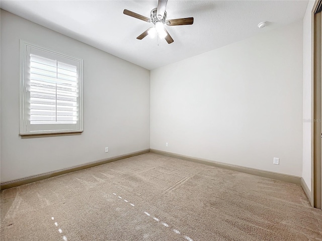 carpeted spare room featuring ceiling fan