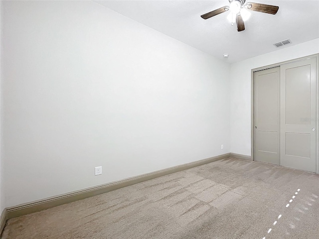 unfurnished bedroom featuring ceiling fan, a closet, and light carpet