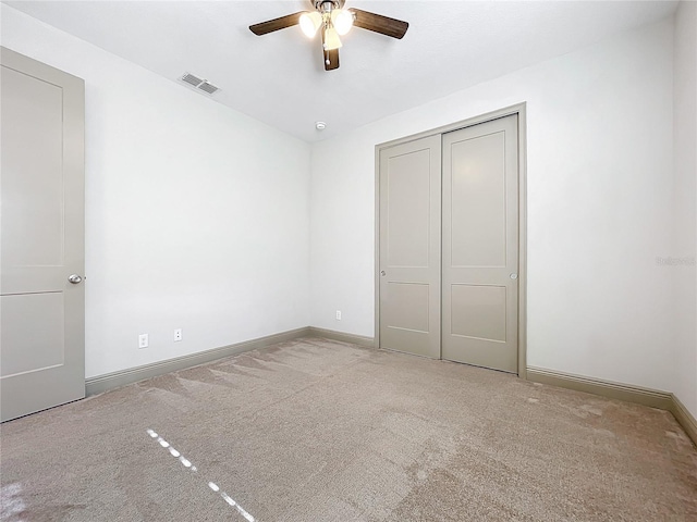 unfurnished bedroom with ceiling fan, carpet floors, and a closet