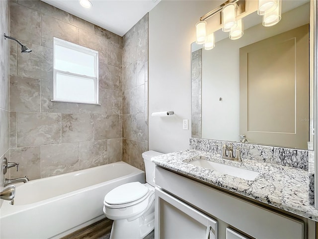 full bathroom featuring tiled shower / bath combo, toilet, wood-type flooring, and vanity