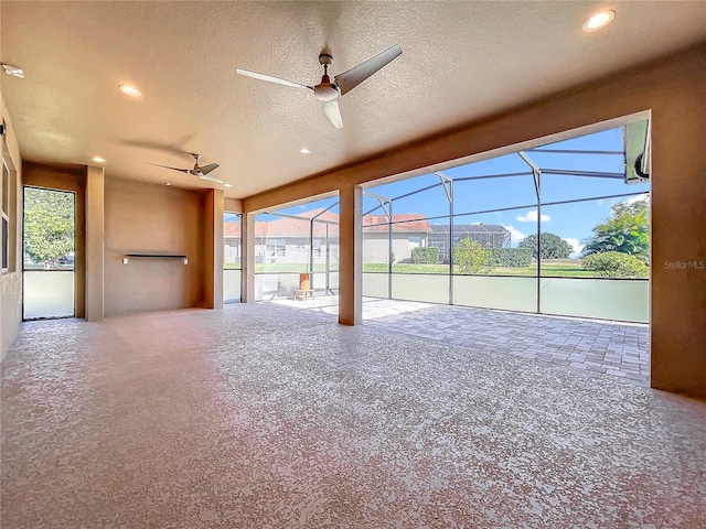 unfurnished living room with ceiling fan, carpet, and a textured ceiling