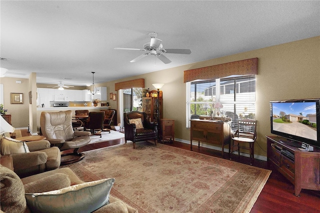 living room with ceiling fan and dark hardwood / wood-style flooring