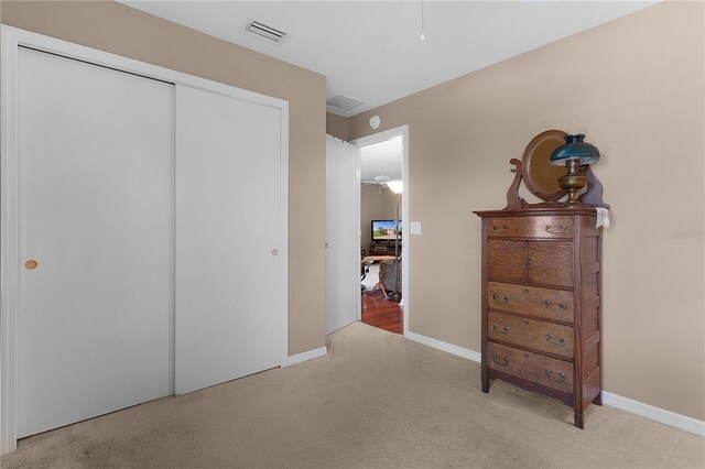 bedroom featuring a closet and light colored carpet