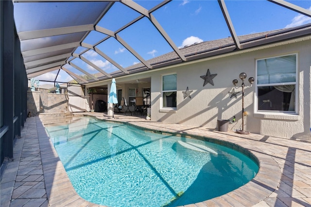 view of pool with a patio, ceiling fan, and a lanai