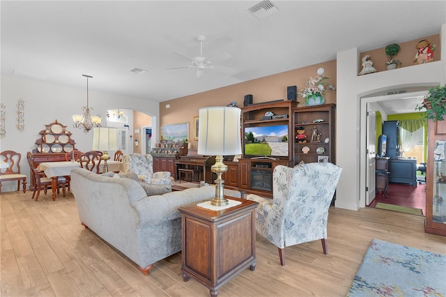 living room featuring light hardwood / wood-style floors and ceiling fan with notable chandelier