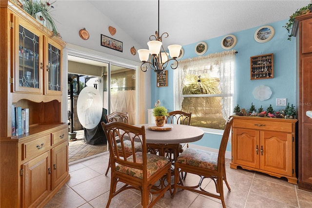 tiled dining room featuring an inviting chandelier and vaulted ceiling