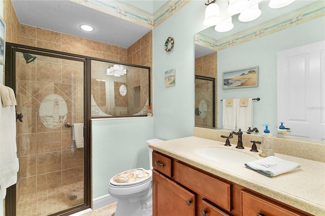 bathroom with a shower with door, vanity, and toilet