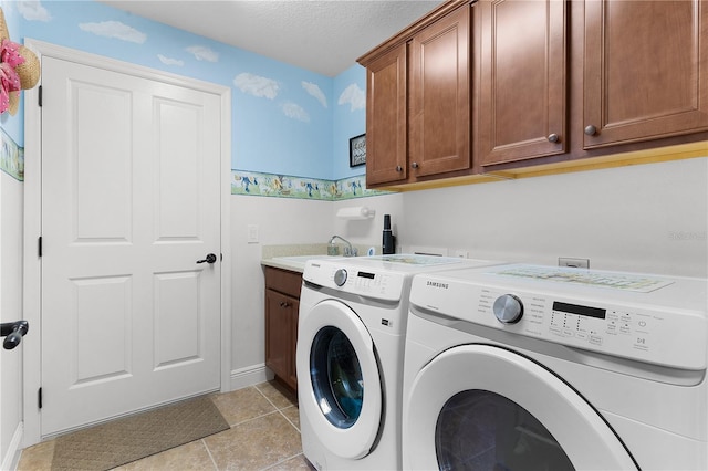 clothes washing area featuring sink, cabinets, a textured ceiling, washer and clothes dryer, and light tile patterned flooring