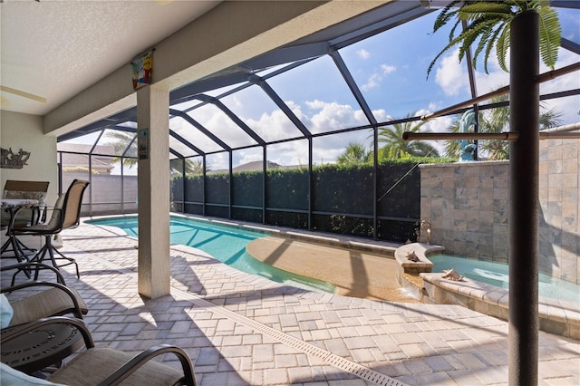 view of pool featuring glass enclosure and a patio area