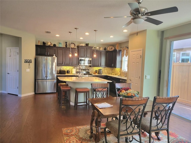 dining space with ceiling fan, sink, and dark wood-type flooring