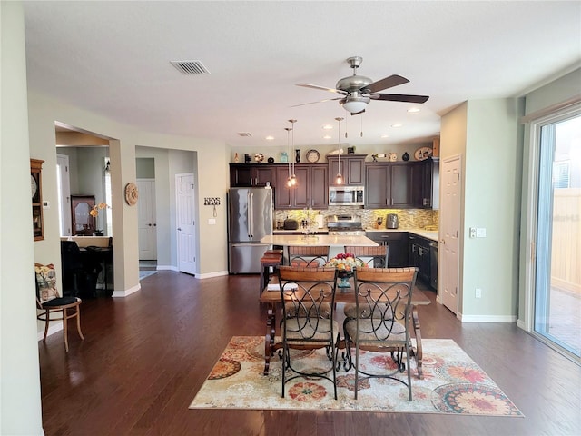 dining area with ceiling fan and dark wood-type flooring