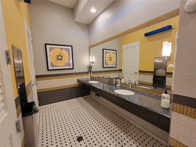 bathroom with tile patterned flooring, vanity, and tile walls