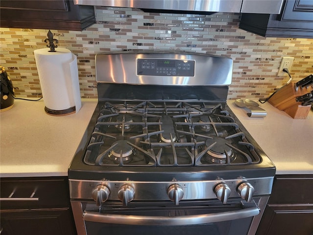 interior details with decorative backsplash and stainless steel range with gas cooktop