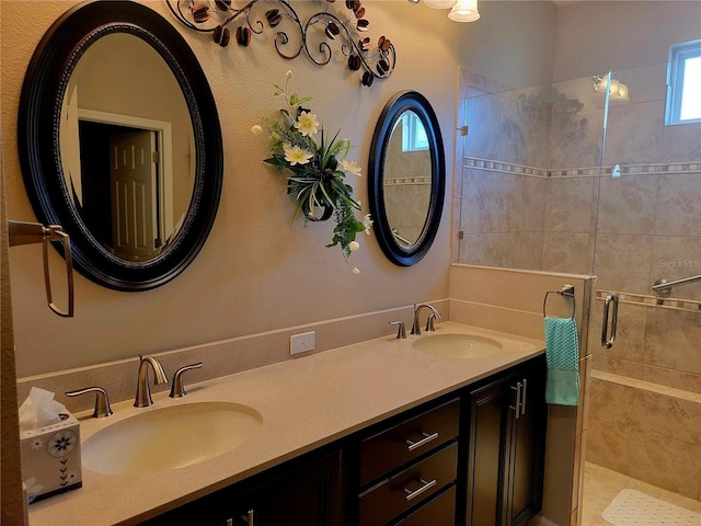 bathroom with tiled shower, vanity, and tile patterned flooring