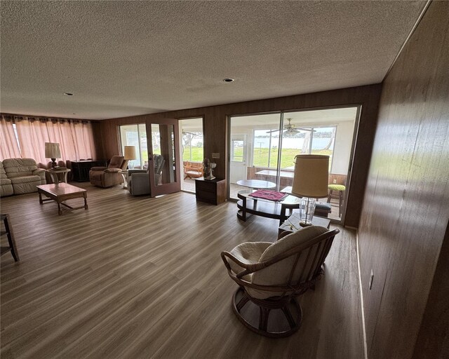 living room with dark wood-type flooring, a textured ceiling, and plenty of natural light