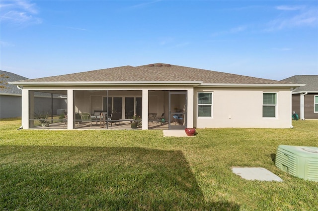 back of property featuring a yard, a patio area, and a sunroom