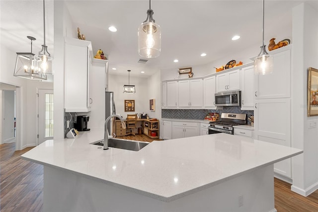 kitchen with hardwood / wood-style flooring, pendant lighting, sink, and appliances with stainless steel finishes