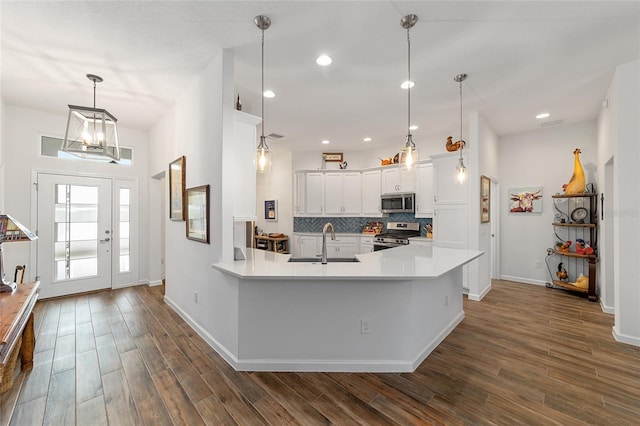 kitchen with white cabinetry, sink, dark hardwood / wood-style floors, backsplash, and appliances with stainless steel finishes