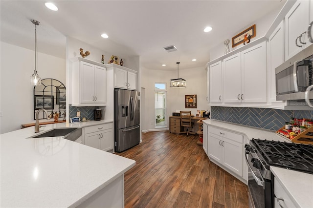 kitchen featuring sink, dark hardwood / wood-style flooring, pendant lighting, white cabinets, and appliances with stainless steel finishes