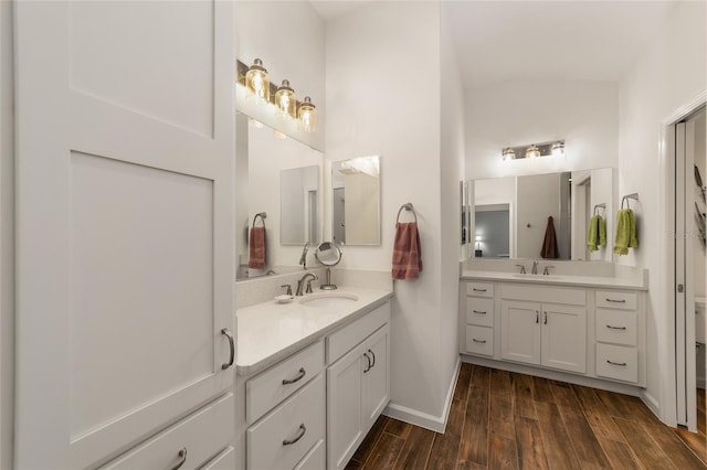 bathroom featuring vanity, wood-type flooring, and vaulted ceiling