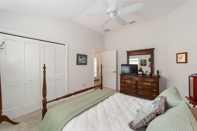 bedroom with ceiling fan, a closet, light colored carpet, and lofted ceiling