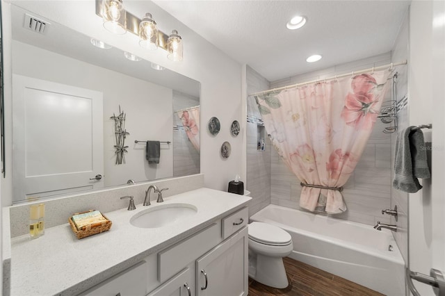 full bathroom featuring hardwood / wood-style floors, vanity, shower / bath combo, and toilet