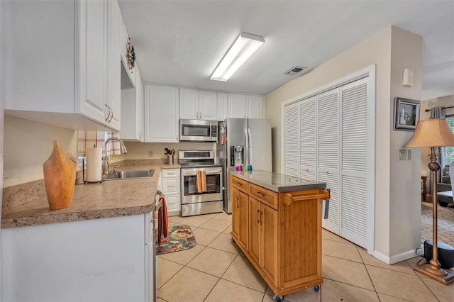 kitchen featuring a kitchen island, sink, white cabinetry, and stainless steel appliances