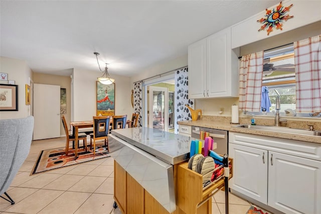 kitchen with sink, pendant lighting, light tile patterned floors, dishwasher, and white cabinetry