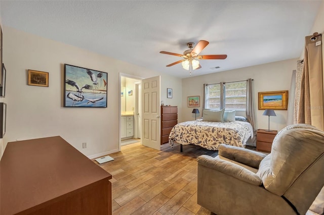 bedroom with ensuite bath, light hardwood / wood-style flooring, and ceiling fan