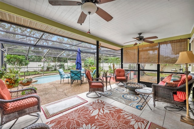 sunroom / solarium featuring ceiling fan, a healthy amount of sunlight, and a swimming pool