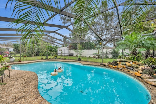 view of swimming pool with glass enclosure and a storage unit