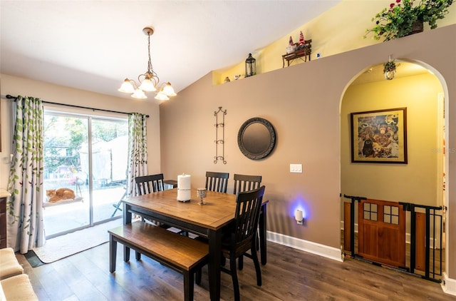 dining area featuring dark hardwood / wood-style flooring, an inviting chandelier, and lofted ceiling