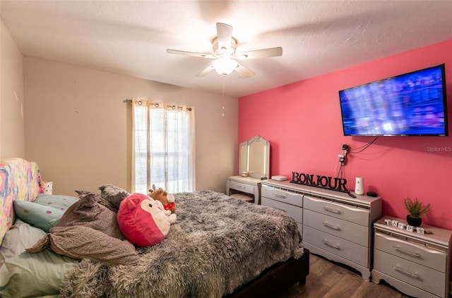 bedroom with a textured ceiling, ceiling fan, and dark hardwood / wood-style floors