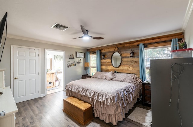 bedroom with multiple windows, wooden walls, ceiling fan, and hardwood / wood-style flooring