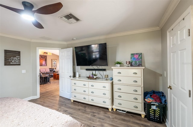 bedroom with dark hardwood / wood-style flooring, ceiling fan, and crown molding