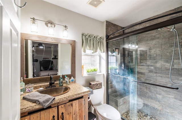 bathroom featuring vanity, toilet, and an enclosed shower