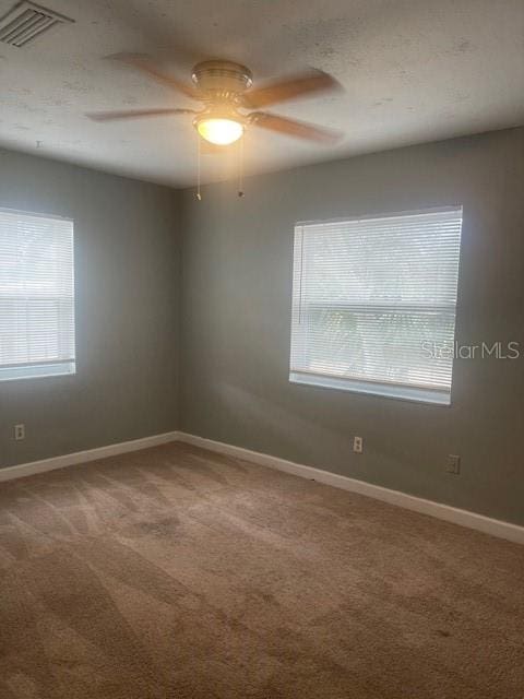 carpeted spare room featuring ceiling fan